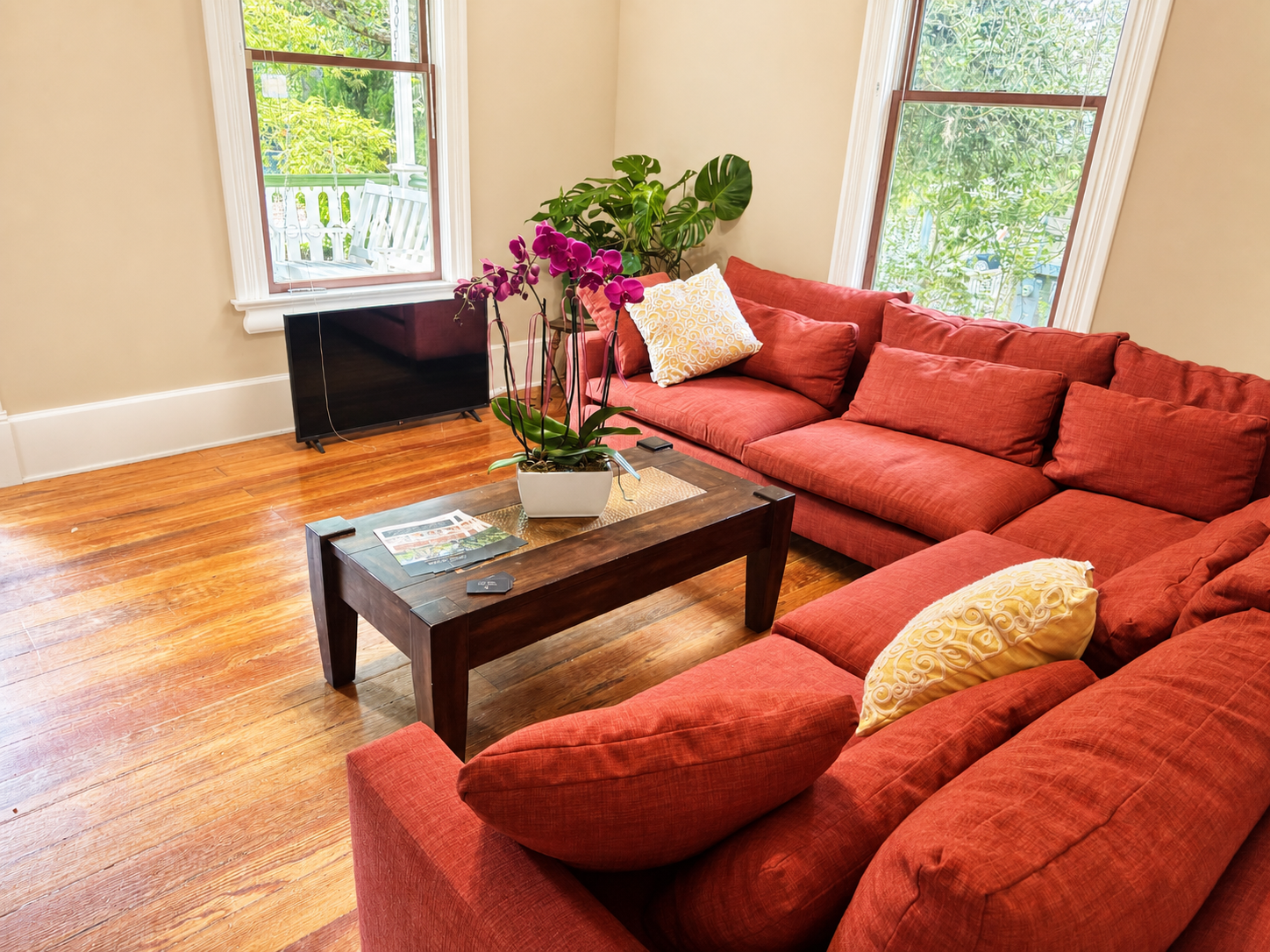 Living room with sectional sofa, orchid, and garden views